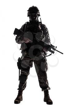 Full length, low key studio shoot of fully equipped army soldier in camo uniform and helmet, armed with pistol and assault service rifle with underbarrel grenade launcher isolated on white background