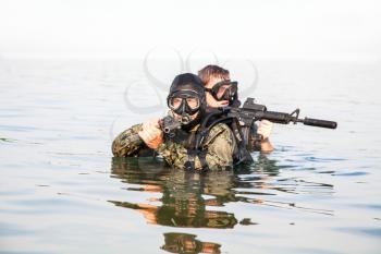 Navy SEAL frogmen with complete diving gear and weapons in the water