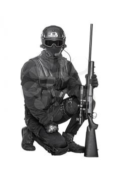 Studio shot of swat operator with sniper rifle wearing black uniforms. Tactical helmet gloves, eyewear and telescopic sight, knee pads