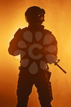Studio shot of swat police special forces automatic rifle black uniforms. Tactical helmet vest eyewear. Orange fire background