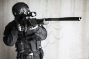 Swat police operator with sniper rifle in black uniforms pointing criminals terrorists defocus shot blurred