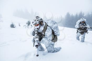 Winter arctic mountains warfare. Action in cold conditions. Pair of special forces weapons in forest somewhere above the Arctic Circle