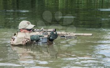 Member of Navy SEAL Team crossing the river with weapons