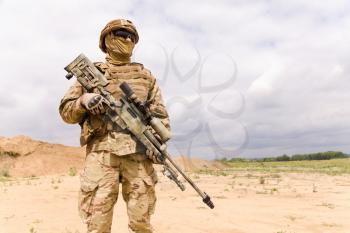 Equipped and armed special forces soldie in the desert, copy space fo text.