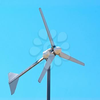 Wind electric turbine generator at blue sky background