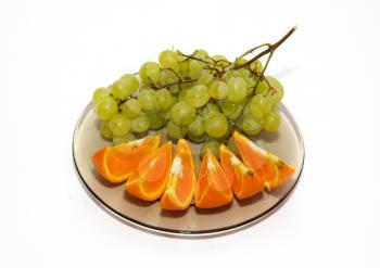 Green grapes and orange isolated on white.