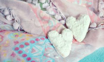 Cookies in the shape of hearts on the textiles background. Boho style. Love concept background. February 14 Holidays. Happy valentines day celebration.