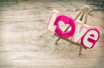 Decorative inscription Love on a small wooden easel that stands in vintage board.