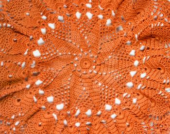 Orange crocheted handmade handkerchief in the form of sunflower.