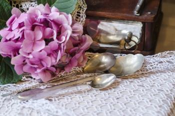 Still life of hydrangea, ancient mirror, silver tablespoon on knitted crocheted napkin. Vintage composition in the style of shabby chic.