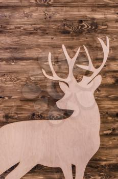 Suluet deer with plywood on the background texture of wood.Christmas photo with place for text.