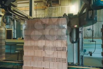 Wrapping a transport film of a brick pallet. Brick production, hollow ceramic bricks factory. Brick production, bricks factory.