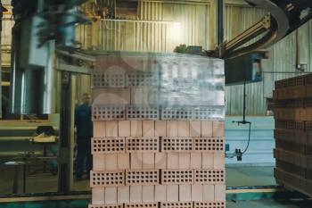 Wrapping a transport film of a brick pallet. Brick production, hollow ceramic bricks factory. Brick production, bricks factory.