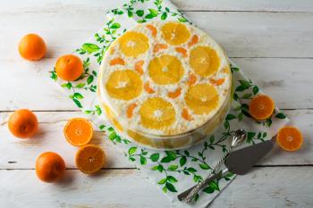 Cold white jelly fruit tart, mousse whipped cream pie yoghurt yogurt souffles cake with orange and tangerine. Homemade fruit gelatin breakfast dessert