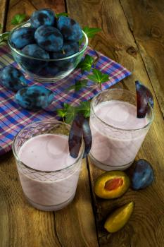 Fresh fruit, plum smoothies, prune yogurt, diet healthy drink in a glass on a dark wooden background, vertical. Selective focus