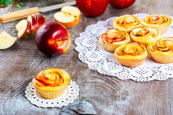 Muffin  with rose shaped apple. Sweet apple dessert pie. Homemade apple rose pastry. Breakfast sweet apple muffins.