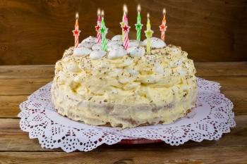 Birthday cake with candles on wooden background. Meringue cake. Pavlova