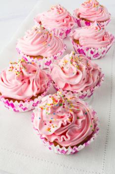Pink cupcakes on the linen napkin. Birthday cupcakes. Homemade cupcake. Sweet cupcake. Gourmet cupcakes. Sweet pastry.  Sweet dessert.