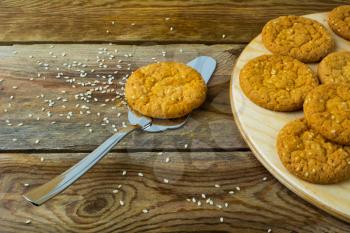Sesame cookies and cake spatula on wooden background. Breakfast cookie. Dessert cookies. Cookies. Cookie. Dessert. Breakfast. Sweet cookie. Homemade cookies. 