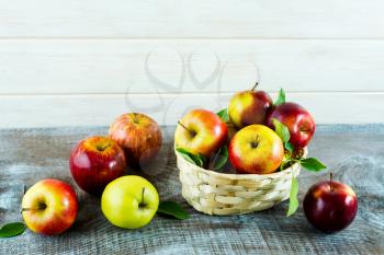 Fresh apples in the small wicker basket. Ripe fruits as healthy eating or vegetarian food concept. 