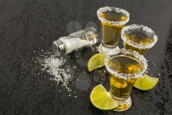 Tequila shots with lime and salt. Tequila. Tequila shot. Gold Mexican tequila