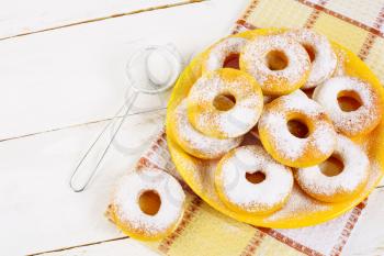 Donuts with caster sugar served on yellow plate top view copy space. Sweet dessert pastry doughnuts.   Hanukkah sweet donuts. 