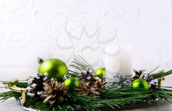 Christmas background with holiday ornaments and candle centerpiece. Christmas decoration with pine cones. Christmas greeting background. Copy space.