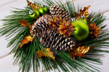 Christmas holiday golden cones and leaves decorated wreath. Christmas decoration with golden decor. Christmas table centerpiece. 