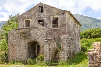 Ancient house built with concrete. Flowering plants growing in the ground. Wooden blocks falling from the ceiling. Ruins during medieval era. History travel