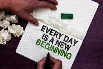 Text sign showing Every Day Is A New Beginning. Conceptual photo you have a chance to dream work live better Man holding marker notebook page crumpled papers several tries mistakes