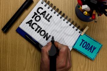 Writing note showing Call To Action. Business photo showcasing Encourage Decision Move to advance Successful strategy Man holding marker notebook clothespin reminder wooden table markers