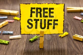 Text sign showing Free Stuff. Conceptual photo Any thing that you can have in a store that is not being paid Clothespin holding yellow paper note several clothespins wooden floor