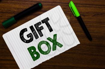 Conceptual hand writing showing Gift Box. Business photo text A small cointainer with designs capable of handling presents Notebook paper markers wooden background communicating ideas