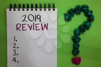 Text sign showing 2019 Review. Conceptual photo seeing important events or actions that made previous year Open notebook crumpled papers forming question mark green background