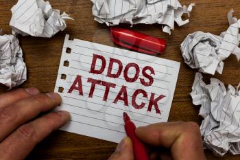 Writing note showing Ddos Attack. Business photo showcasing perpetrator seeks to make network resource unavailable Man holding marker notebook page crumpled paper several tries mistakes