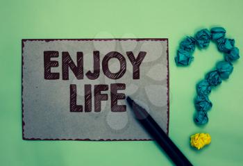 Word writing text Enjoy Life. Business concept for Any thing, place,food or person, that makes you relax and happy Gray paper marker crumpled papers forming question mark green background