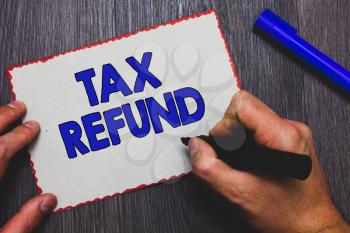 Writing note showing Tax Refund. Business photo showcasing applied when money liability is less than the paid ones Man holding marker paper red borders express ideas Wooden background