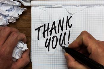 Text sign showing Thank You. Conceptual photo replaying on something good or greetings with pleased way Man holding marker notebook crumpled papers ripped pages mistakes made