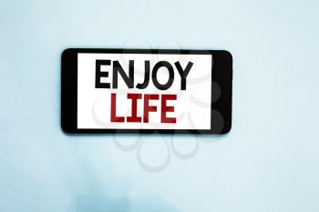 Text sign showing Enjoy Life. Conceptual photo Any thing, place,food or person, that makes you relax and happy Cell phone white screen over light blue background text messages apps