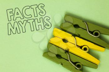 Text sign showing Facts Myths. Conceptual photo work based on imagination rather than on real life difference Three green yellow vintage clothespins clear background Holding things