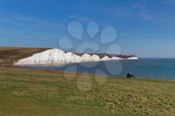 SEAFORD, SUSSEX/UK - APRIL 5 : Man Sitting on a Bench overlooking the Seven Sisters near Seaford in Sussex on April 5, 2018. Unidentified Man.