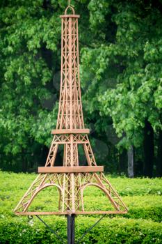 Decorative fake Eiffel tower of brown color in the park.