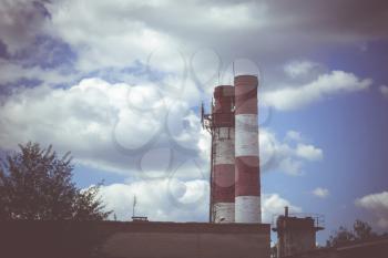 Old industry smoke stack over sunny blue sky.