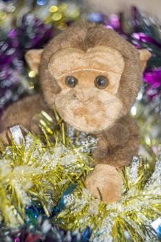 Brown monkey toy with decorated Christmas tree.