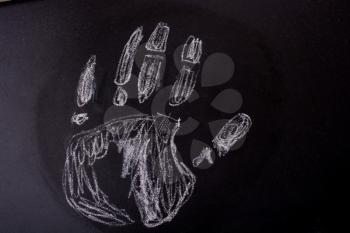 Handprint drawn by  white chalk on a blackboard