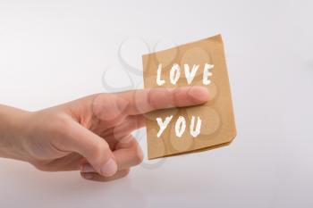 Love You text on paper in hand  over white background