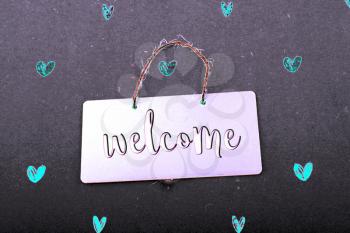 Welcome wording on black notice board  with red hearts around