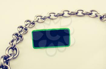 Small green sided black noticeboard surrounded by chain on a white background