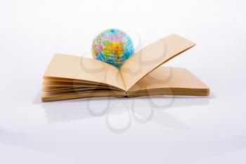 Globe near a notebook on a white background