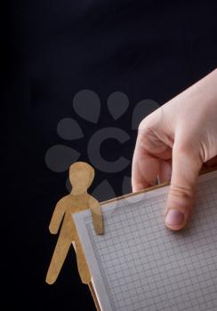 Man shape cut out of paper in notebbok in hand